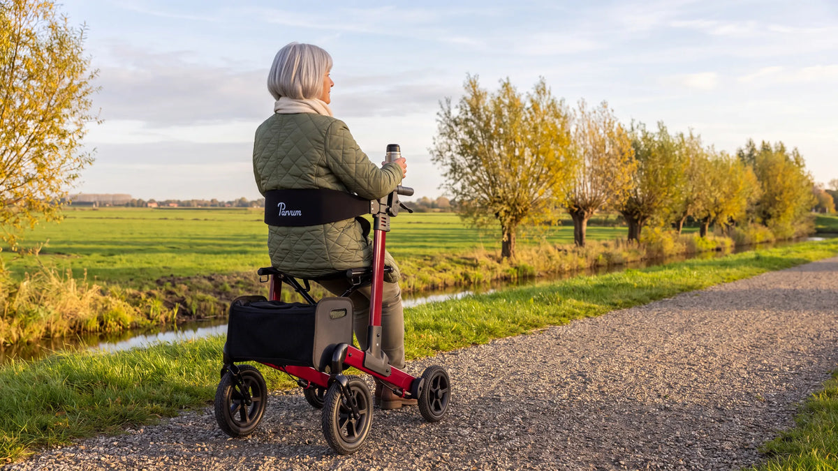 Parvum Luxo Air in ruby red beside a small polder ditch; a woman sits on the rollator with a cup of tea.